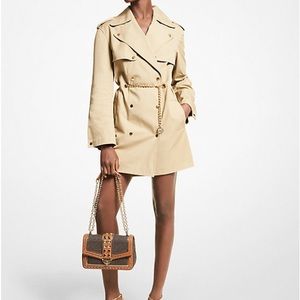 Khaki trench coat with a chain belt.